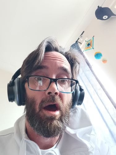Client portant un casque Oneodio noir chez lui